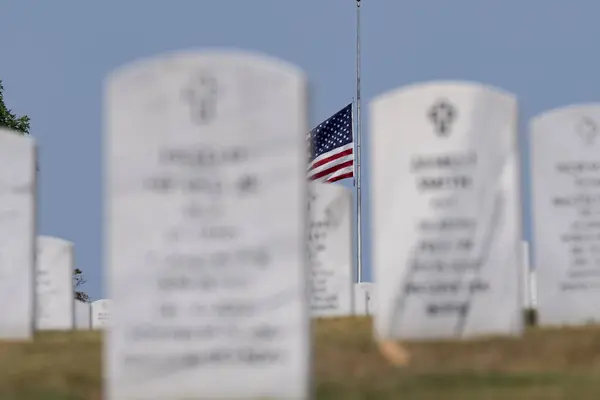 stock image Generic views of a veterans cemetery on a serene day, featuring American flags fluttering in the breeze as a memorial celebration honors those who served.