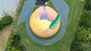 The Peachoid is a 135-foot water tower in Gaffney, SC, resembles a peach and holds 1 million gallons. Built in 1981, its a landmark on I-85, showcasing unique architecture and attracting tourists. clipart