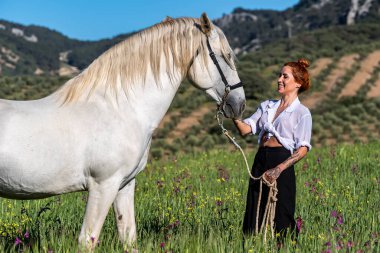 Muhteşem İspanyol bayan ve görkemli Endülüs atı güzelliği ve zarafeti yemyeşil tarlada somutlaştırıyor..