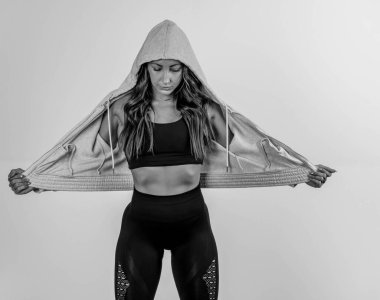 Göz kamaştırıcı atletik formda bir model stüdyoda güven içinde poz veriyor, yumuşak ışıklandırmayla vurgulanmış kasları. Gücünü ve zarafetini sergiliyor. Göz kamaştırıcı fiziğini göstererek gösterişli, minimalist bir ortamda..