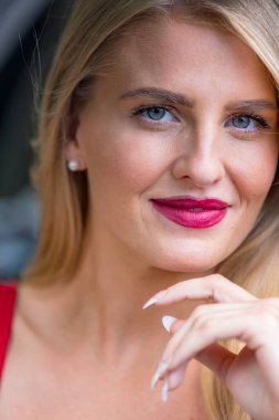 Işıl ışıl sarışın bir kadın kıtır sonbahar havasının tadını çıkarıyor. Gözleri altın güneş ışığında parıldıyor. Sıcak parıltı, onun genç tenini ön plana çıkarıyor. Açık havada güzellik ve huzur dolu mükemmel bir an yaratıyor..