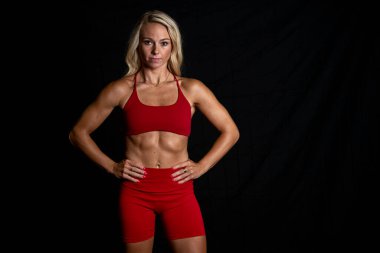 Göz kamaştırıcı atletik formda bir model stüdyoda güven içinde poz veriyor, yumuşak ışıklandırmayla vurgulanmış kasları. Gücünü ve zarafetini sergiliyor. Göz kamaştırıcı fiziğini göstererek gösterişli, minimalist bir ortamda..