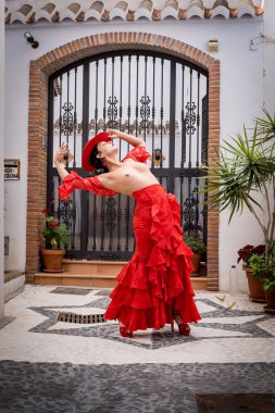 Büyüleyici üstsüz İspanyol modeli, Frigiliana sokaklarında geleneksel kıyafetlerini sergiliyor..