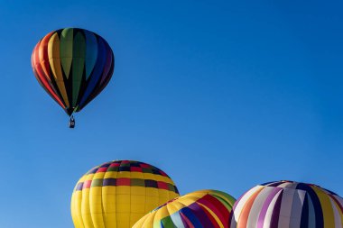 Tüm şekil ve renklerden oluşan canlı hava balonları açık mavi gökyüzüne doğru süzülür ve canlı bir sonbahar balonu festivalinde havayı heyecanla doldurur. Mevsimin güzelliğine karşı sahne nefes kesici..