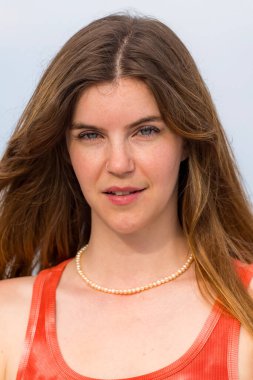 Göz kamaştırıcı bir kızıl saçlı model, marinanın pırıl pırıl mavisiyle çevrili ılık bahar güneşinde güneşleniyor. Yelkenliler yavaşça sallanıyor. Açık deniz, sonsuz uzaklığa uzanıyor..