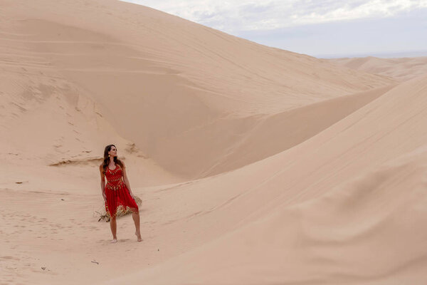 Грациозная модель охватывает красоту природы в песчаных дюнах, олицетворяя элегантность на фоне огромного природного великолепия