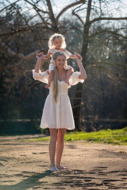 Bir anne ve güzel kızı, huzurlu bir dere kenarında gülüp eğleniyorlar. Doğanın nazik sesleriyle çevrili bu güzel bahar gününde özel bağlarını korurlar..