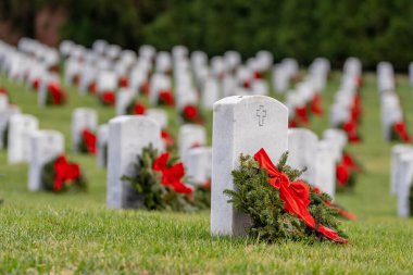 Atop a hill, a veterans cemetery with white headstones and the American flag evokes deep honor, sacrifice, and enduring national pride. clipart