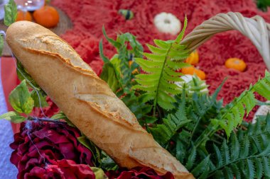 A vibrant fall picnic spread features colorful seasonal foodsbright pumpkins apples charcuterie  fresh bread cheese and warm drinks. Surrounded by golden leaves and cozy blankets in the crisp autumn air. clipart