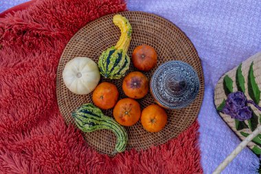 A vibrant fall picnic spread features colorful seasonal foodsbright pumpkins apples charcuterie  fresh bread cheese and warm drinks. Surrounded by golden leaves and cozy blankets in the crisp autumn air. clipart