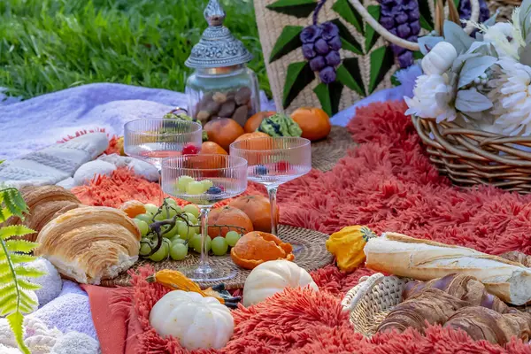 Canlı bir sonbahar pikniği rengarenk mevsimlik besin, balkabağı, elma, taze ekmek, peynir ve sıcak içecekler sunar. Güz havasında altın yapraklar ve rahat battaniyelerle çevrili..