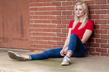 A beautiful blonde woman poses joyfully for the camera, showcasing her stylish spring clothing. With a bright smile and playful demeanor, she radiates happiness, embracing the upcoming gorgeous weather. clipart