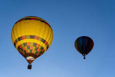 Tüm şekil ve renklerden oluşan canlı hava balonları açık mavi gökyüzüne doğru süzülür ve canlı bir sonbahar balonu festivalinde havayı heyecanla doldurur. Mevsimin güzelliğine karşı sahne nefes kesici..