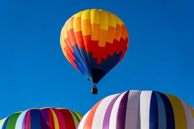 Tüm şekil ve renklerden oluşan canlı hava balonları açık mavi gökyüzüne doğru süzülür ve canlı bir sonbahar balonu festivalinde havayı heyecanla doldurur. Mevsimin güzelliğine karşı sahne nefes kesici..