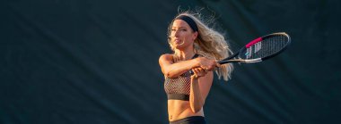 Enerjiyle parlayan genç ve güzel bir atlet, parlak yaz güneşi altında yoğun bir tenis turu atıyor. Onun hızlı hareketleri ve odaklanmış bakışları zarafeti, gücü ve oyuna olan tutkusunu simgeliyor..