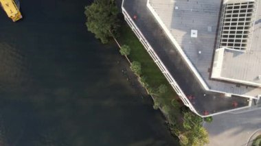 Tampa, Florida 'nın hava manzarası modern yüksek binalarla dolu canlı bir ufuk çizgisi, şehir merkezinden geçen ikonik Hillsborough Nehri, Tampa Körfezi boyunca geniş deniz kenarları ve yemyeşil noktalı kentsel alanlar gösteriyor..