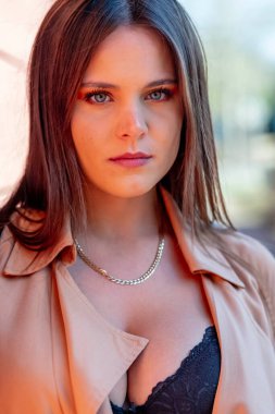 Göz kamaştırıcı bir esmer yaşam tarzı modeli canlı sonbahar yapraklarıyla çevrili açık havada zarifçe poz verir. Zarif bir şekilde ışıldıyor, rahat elbisesi sezonun serin havasını ve altın renklerini tamamlıyor..