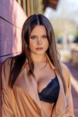 Göz kamaştırıcı bir esmer yaşam tarzı modeli canlı sonbahar yapraklarıyla çevrili açık havada zarifçe poz verir. Zarif bir şekilde ışıldıyor, rahat elbisesi sezonun serin havasını ve altın renklerini tamamlıyor..