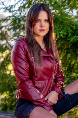 Göz kamaştırıcı bir esmer yaşam tarzı modeli canlı sonbahar yapraklarıyla çevrili açık havada zarifçe poz verir. Zarif bir şekilde ışıldıyor, rahat elbisesi sezonun serin havasını ve altın renklerini tamamlıyor..