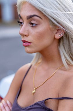 Canlı genç bir kadın, bahar sıcağının tadını çıkararak hareketli şehir sokaklarında yürüyor. Etrafında yüksek binalar yükseliyor ve onun ışıl ışıl neşesi şehir hayatının enerjisini yansıtıyor..