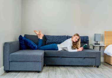 Çekici sarışın bir model şık, güneşli evinde rahatlar ve kitap okur. Onun sakin sabahı, şık iş gününe geçmeden önce tonu belirler..