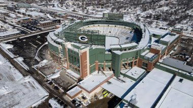 Lambeau Field 'ın hava görüntüsü 81441 taraftar kapasiteli sembolik kase şeklindeki stadyumu gösteriyor. Otoparklar ve Titletown Bölgesi ile çevrili olan stadyum, NFL 'in en eski ve sürekli faaliyet gösteren stadyumu olarak duruyor..