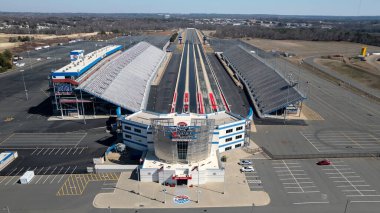 An aerial view of ZMax Dragway in Concord, NC reveals a state-of-the-art, four-lane drag strip with grandstands flanking both sides. The facility hosts NHRA Four-Wide and Carolina Nationals events. clipart