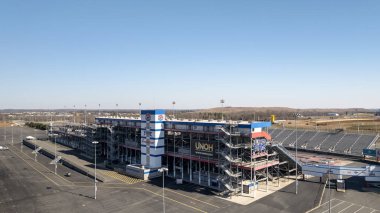 An aerial view of ZMax Dragway in Concord, NC reveals a state-of-the-art, four-lane drag strip with grandstands flanking both sides. The facility hosts NHRA Four-Wide and Carolina Nationals events. clipart