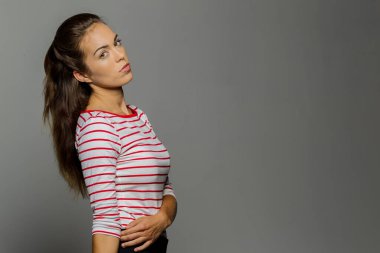 Muhteşem bir esmer model minimalist stüdyo ortamında çarpıcı bir poz veriyor. Onun zarafeti ve güzelliği sahnenin basitliği ve odağı ile gelişir..