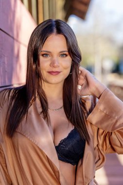 Göz kamaştırıcı bir esmer yaşam tarzı modeli canlı sonbahar yapraklarıyla çevrili açık havada zarifçe poz verir. Zarif bir şekilde ışıldıyor, rahat elbisesi sezonun serin havasını ve altın renklerini tamamlıyor..