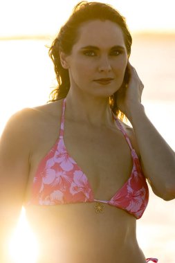 Çekici sarışın bir model, sakin bir Meksika plajında güven içinde poz veriyor. Güzelliği altın kum, nazik dalgalar ve nefes kesen doğal zarafetin sergilenen sıcak tropikal esintisiyle uyum içinde..