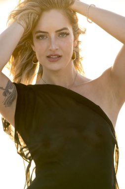 Çekici sarışın bir model, sakin bir Meksika plajında güven içinde poz veriyor. Güzelliği altın kum, nazik dalgalar ve nefes kesen doğal zarafetin sergilenen sıcak tropikal esintisiyle uyum içinde..