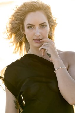 Çekici sarışın bir model, sakin bir Meksika plajında güven içinde poz veriyor. Güzelliği altın kum, nazik dalgalar ve nefes kesen doğal zarafetin sergilenen sıcak tropikal esintisiyle uyum içinde..