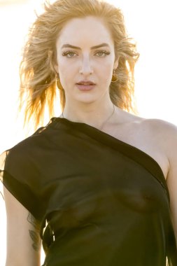 Çekici sarışın bir model, sakin bir Meksika plajında güven içinde poz veriyor. Güzelliği altın kum, nazik dalgalar ve nefes kesen doğal zarafetin sergilenen sıcak tropikal esintisiyle uyum içinde..