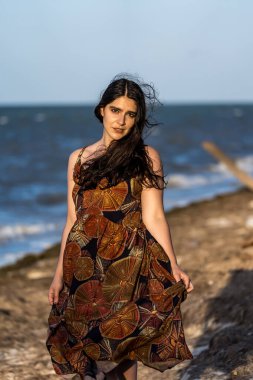 Çarpıcı esmer bir kadın, Meksika tatilinde neşeli pozlar veriyor. Güzelliği, sıcak güneş ve nefes kesici manzarayla gelişiyor. Kaygısız bir ruh yayıyor, neşeli bayram havasını kucaklıyor..