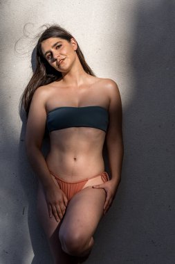 Göz kamaştırıcı bir İspanyol esmer bikini modeli güneşli bir Meksika çiftliğinde zarifçe poz veriyor. Zarafet saçıyor, hareketli tatil atmosferini kucaklıyor..