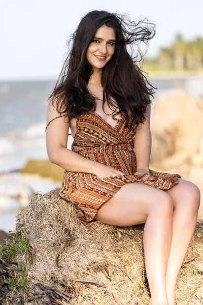 Çarpıcı esmer bir kadın, Meksika tatilinde neşeli pozlar veriyor. Güzelliği, sıcak güneş ve nefes kesici manzarayla gelişiyor. Kaygısız bir ruh yayıyor, neşeli bayram havasını kucaklıyor..