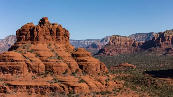 Yukarıdan, Sedona 'nın çarpıcı kırmızı kumtaşı oluşumları güneş ışığı altında parlayan manzaraya hükmediyor. Şehir Coconino Ulusal Ormanı 'nın içine yerleşmiştir. Etrafı çarpıcı çöl arazileri ve yürüyüş yollarıyla çevrilidir..