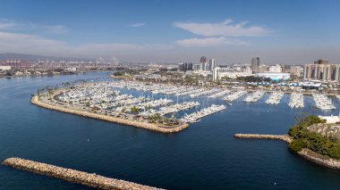 Long Beach 'in havadan görünüşü yoğun bir limanı, ikonik Kraliçe Mary' si, manzaralı deniz manzarası ve genişleyen kentsel manzarası olan canlı bir kıyı şehrini gözler önüne seriyor..