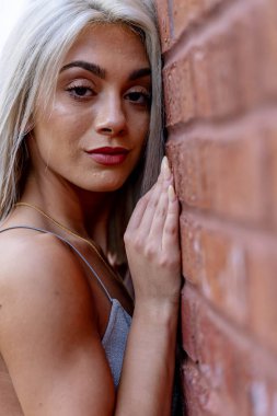 Canlı genç bir kadın, bahar sıcağının tadını çıkararak hareketli şehir sokaklarında yürüyor. Etrafında yüksek binalar yükseliyor ve onun ışıl ışıl neşesi şehir hayatının enerjisini yansıtıyor..