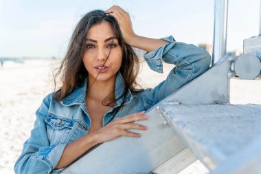 Göz kamaştırıcı melez bir bikini modeli güneşli bir plajda dinleniyor, parlayan tenini güneş öpüyor. Ferahlatıcı dalgaları, kendine güveni, zarafet ve güzellik saçan okyanus arkaplanını seviyor..
