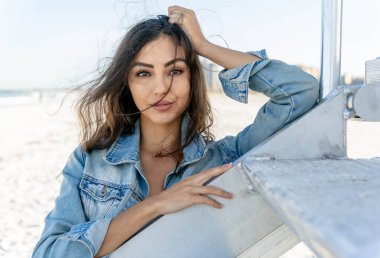 Göz kamaştırıcı melez bir bikini modeli güneşli bir plajda dinleniyor, parlayan tenini güneş öpüyor. Ferahlatıcı dalgaları, kendine güveni, zarafet ve güzellik saçan okyanus arkaplanını seviyor..