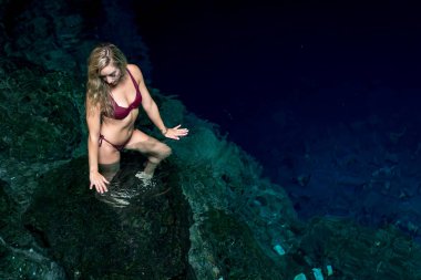 Cuzama, Yucatan, Meksika 'da, büyüleyici bir model, bir mezarlığın mavi ve yeşil sularının canlı renklerinde eğlenerek doğal güzelliğin resimsel bir manzarasını yaratıyor..