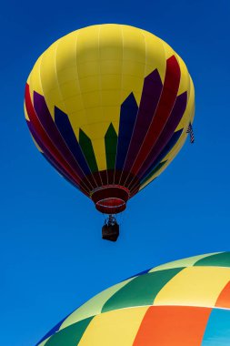 Tüm şekil ve renklerden oluşan canlı hava balonları açık mavi gökyüzüne doğru süzülür ve canlı bir sonbahar balonu festivalinde havayı heyecanla doldurur. Mevsimin güzelliğine karşı sahne nefes kesici..