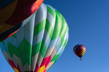Tüm şekil ve renklerden oluşan canlı hava balonları açık mavi gökyüzüne doğru süzülür ve canlı bir sonbahar balonu festivalinde havayı heyecanla doldurur. Mevsimin güzelliğine karşı sahne nefes kesici..