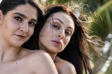 İki muhteşem kadın Karayip tatillerini kucaklıyor, kameraya parlak gülümsemelerle poz veriyorlar. Göz kamaştırıcı manzaralarla çevrelenmiş, unutulmaz kaçışlarının güzelliğini, macerasını ve neşesini yakalıyorlar..