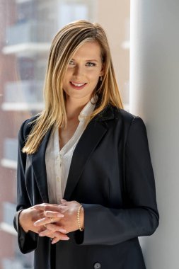 Çekici sarışın bir model şık, güneşli evinde rahat rahat giyiniyor. Onun sakin sabahı, şık iş gününe geçmeden önce tonu belirler..