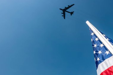 Bir B-52 stadyumun üzerinde süzülüyor, açık mavi gökyüzünde beyaz bir kontrastı takip ediyor. Aşağıda, bir Amerikan bayrağı gururla dalgalanıyor, maç boyunca derin vatanseverlik ve gurur uyandırıyor..