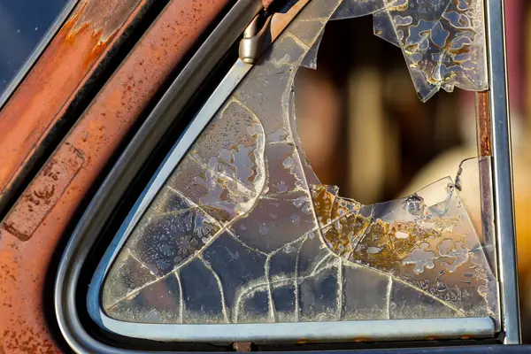 Eski, paslı, boyalı ve kırık camlı bir kamyonun yakın çekimi. Yıpranmış metal yılların eskimesini gösterir, zorlu yolculukların ve unutulmuş günlerin hikâyelerini anlatır..