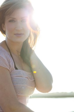 Genç bir esmer model, güzel bir sabahta, güvenli bir şekilde dışarıda poz verir. Güneş ışığı, doğanın sakin güzelliğinin arka planına karşı dik duran yüzlerine yumuşak bir parıltı saçar..